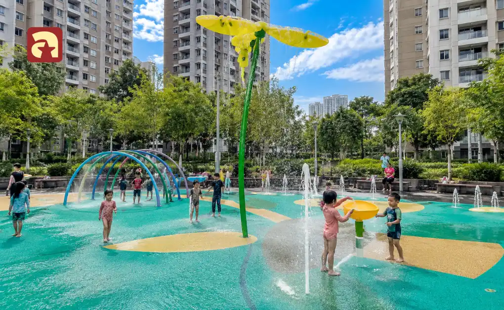 Children playing in water play area with splash pads and fountains at Buangkok Square Park in Singapore